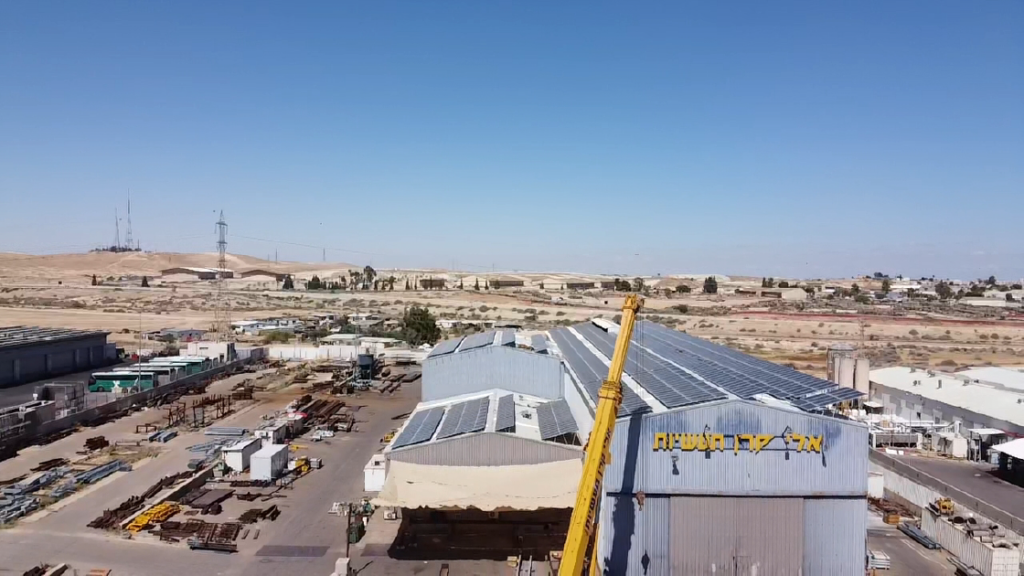 תמונה של אלי קרן תעשיות ממבת על עם תאים סולארים על הגג מנוף בצבע צהוב באמצע התמונה